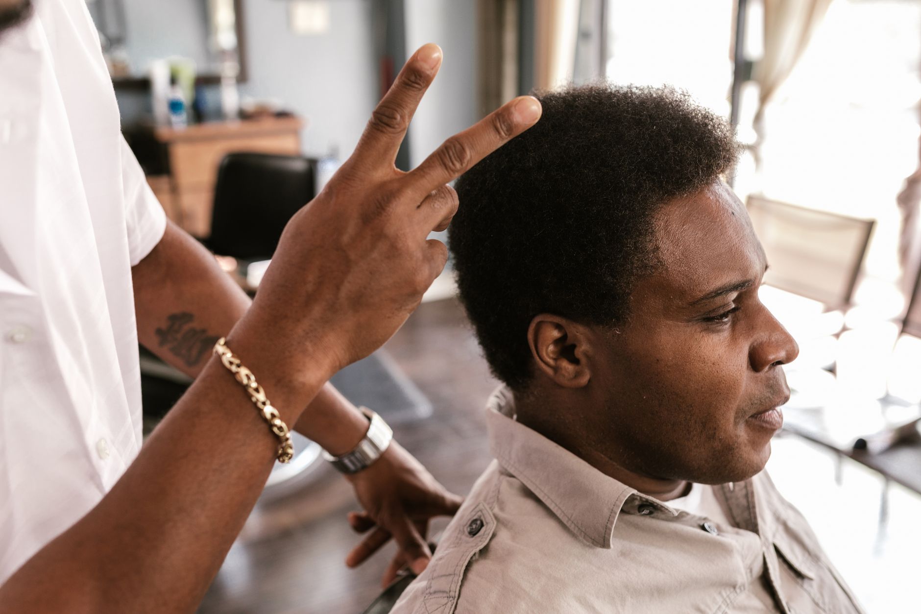 A barber finishing a customer's cut.